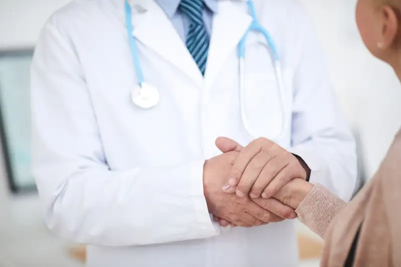 A weight-loss doctor holds a patient’s hand during a consultation in Ponte Vedra, FL.